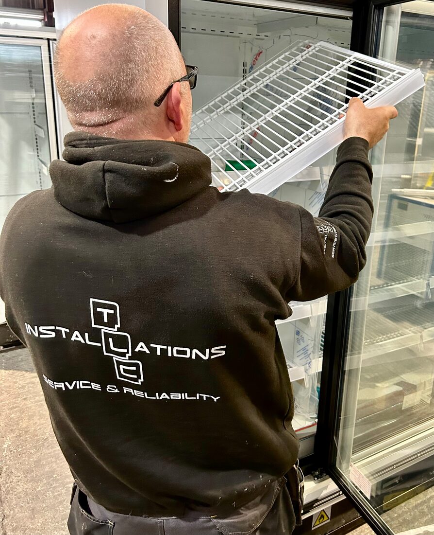 TLC engineer installing a refrigerated glass display cabinet